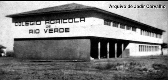 A imagem apresenta um galpão grande em preto e branco de dois andares com diversas janelas e está escrito na parede da fachada em cima colégio agrícola de Rio Verde.