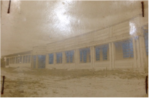 Fotografia da Escola de Iniciação Agrícola de Araquari. A imagem está um tanto apagada, mas apresenta uma longa fachada horizontal, repleta de janelas e uma porta central.
